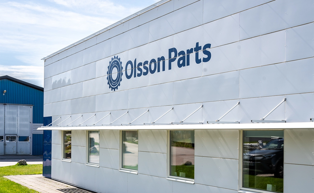 Olsson Parts kontorsbyggnad i Ell&ouml;s med logotyp och f&ouml;nsterrad.