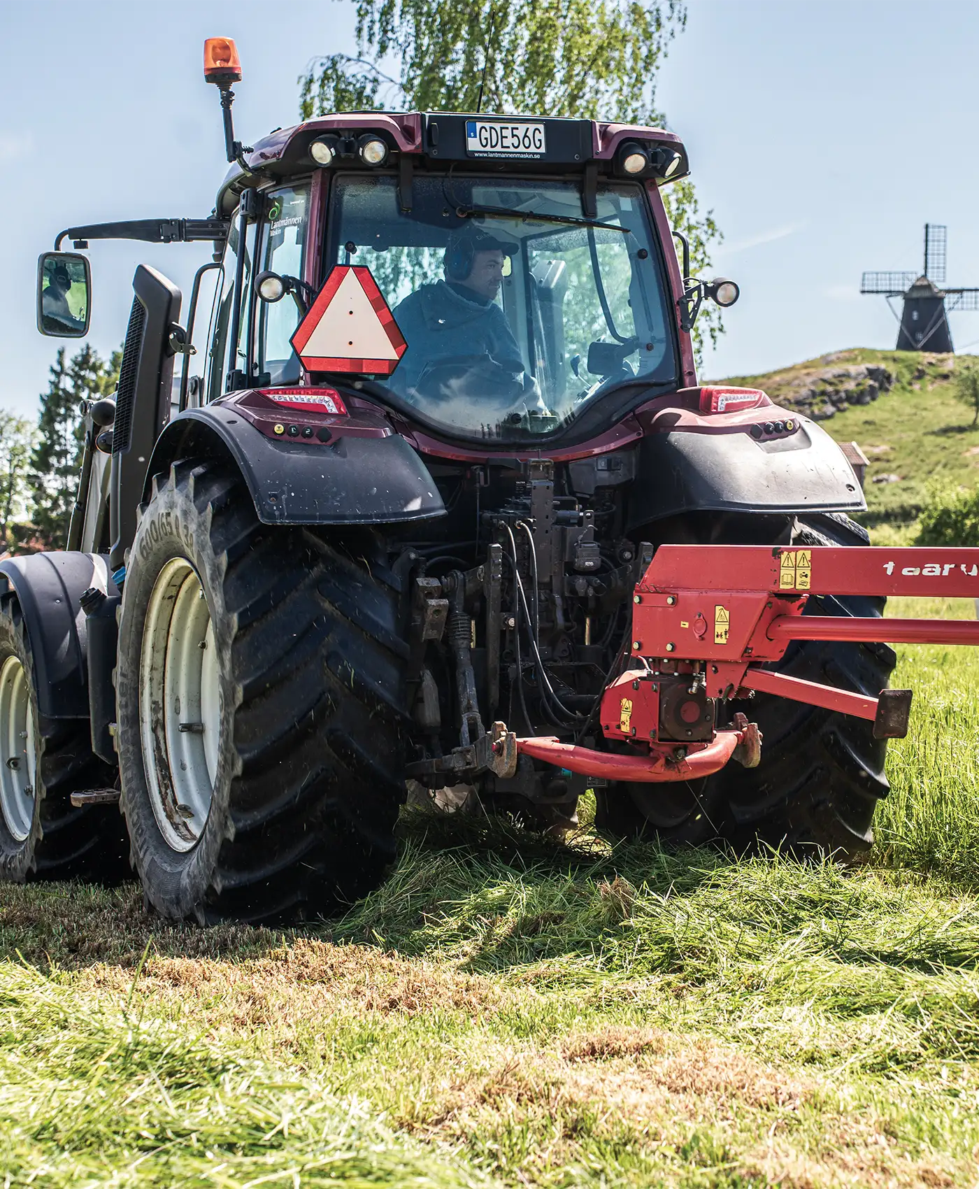 En Valtra-traktor kör ute på ett fält.