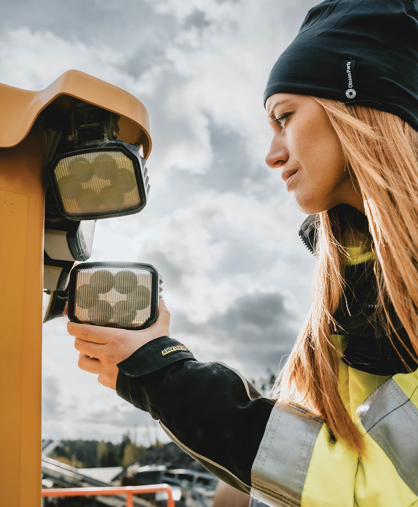 En person monterar arbetsbelysning p&aring; en Volvo hjullastare.