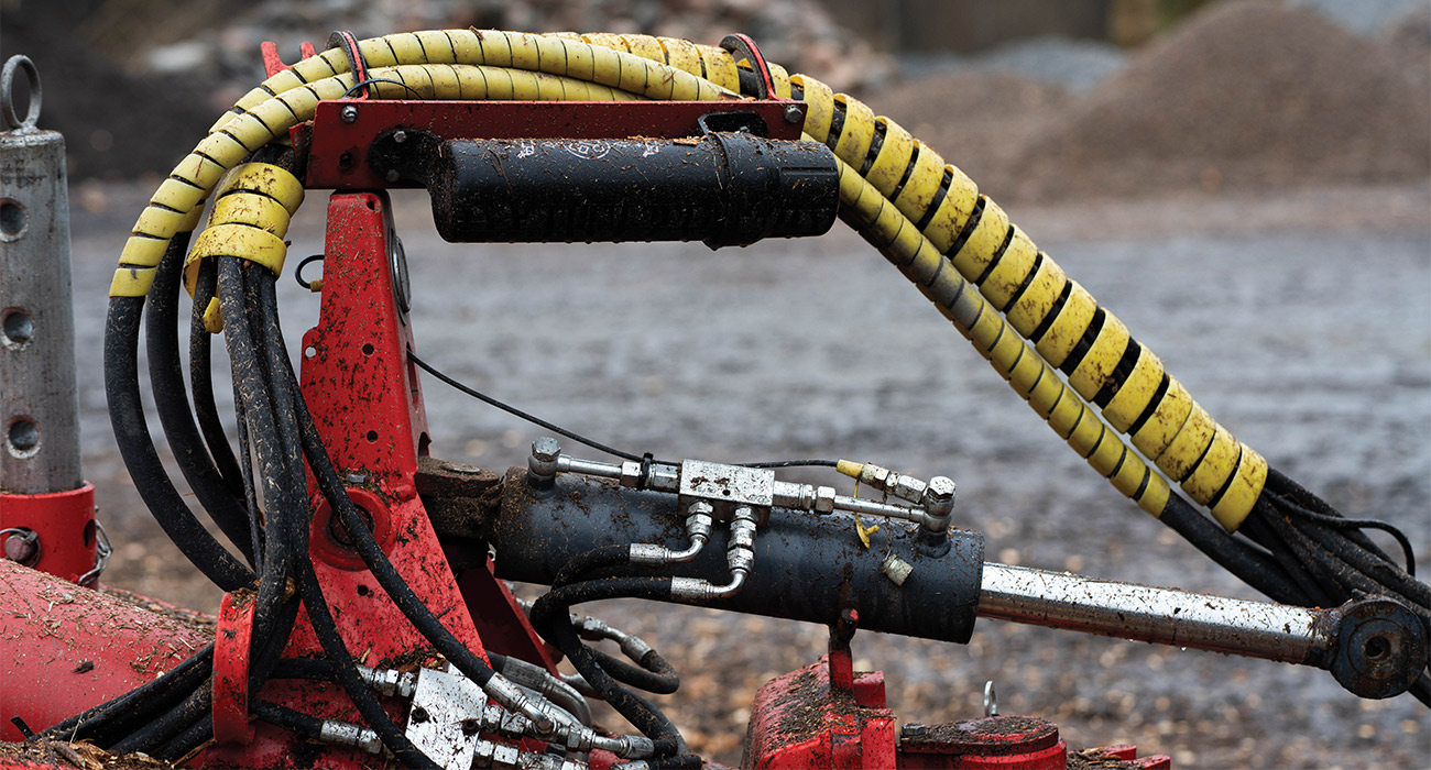 En hydraulcylinder monterad på en röd vagn.