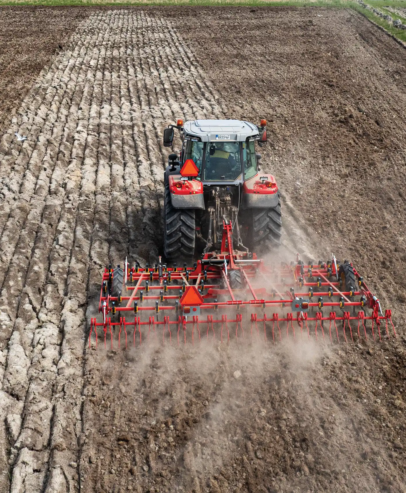 En Massey Ferguson traktor harvar p&aring; ett f&auml;lt.