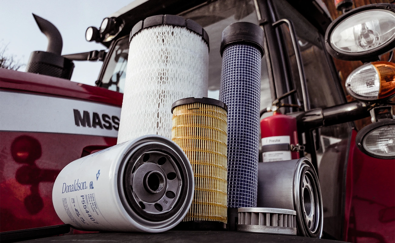Ein Filtersatz steht auf dem Kotflügel eines Massey Ferguson Traktors.