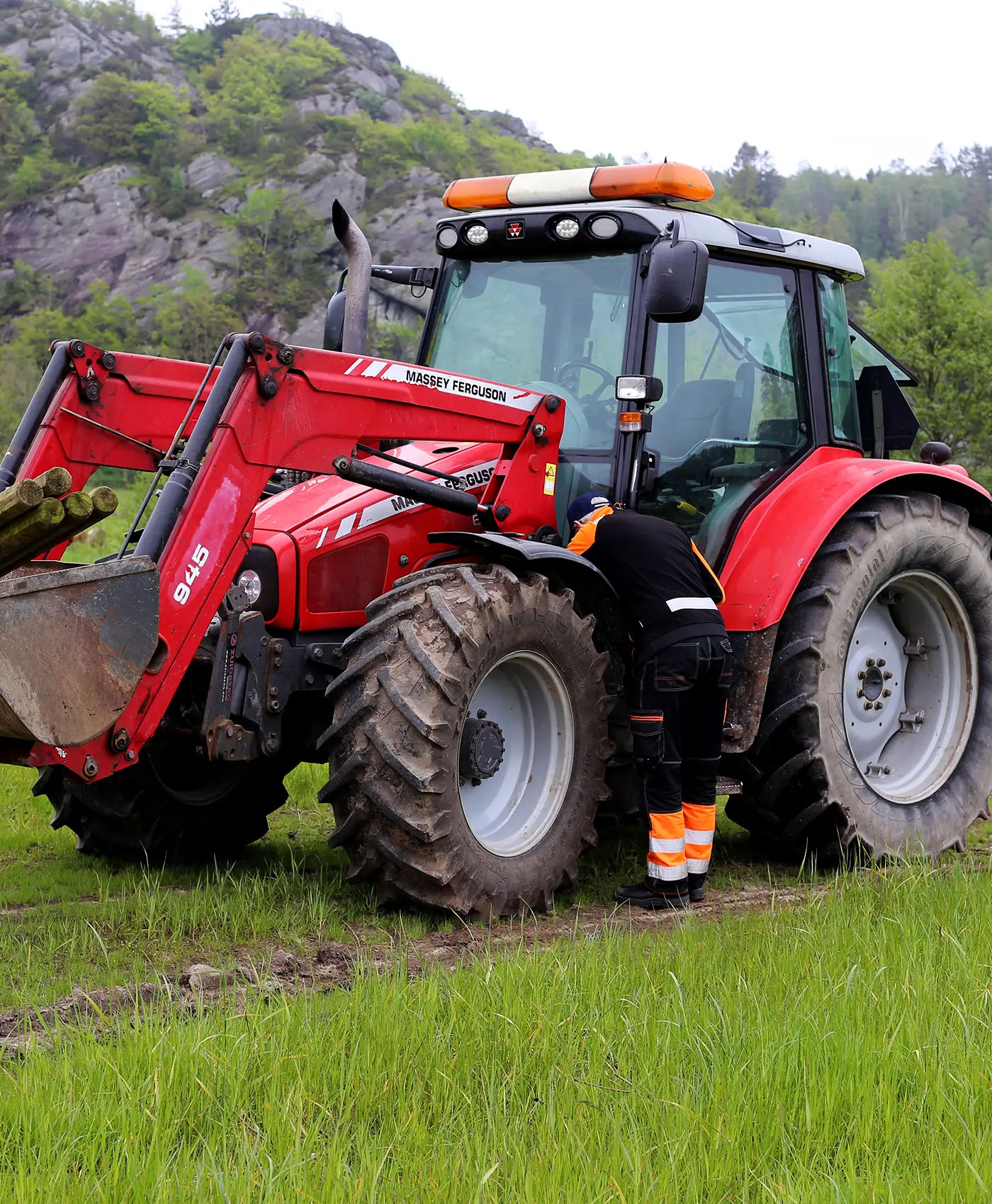 Eine Person arbeitet an einem Massey Ferguson Traktor.