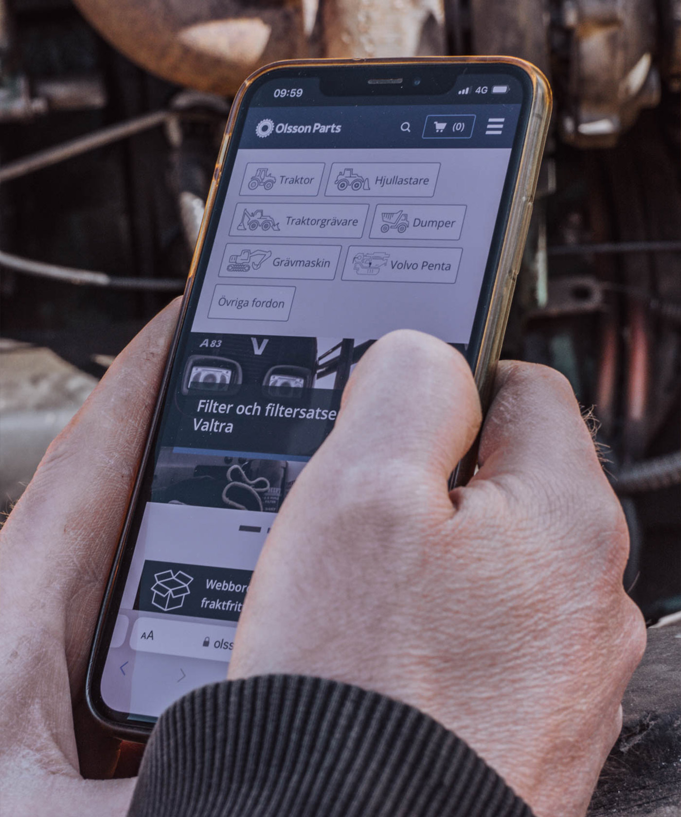 En person som håller i en telefon med Olsson Parts hemsida på skärmen.