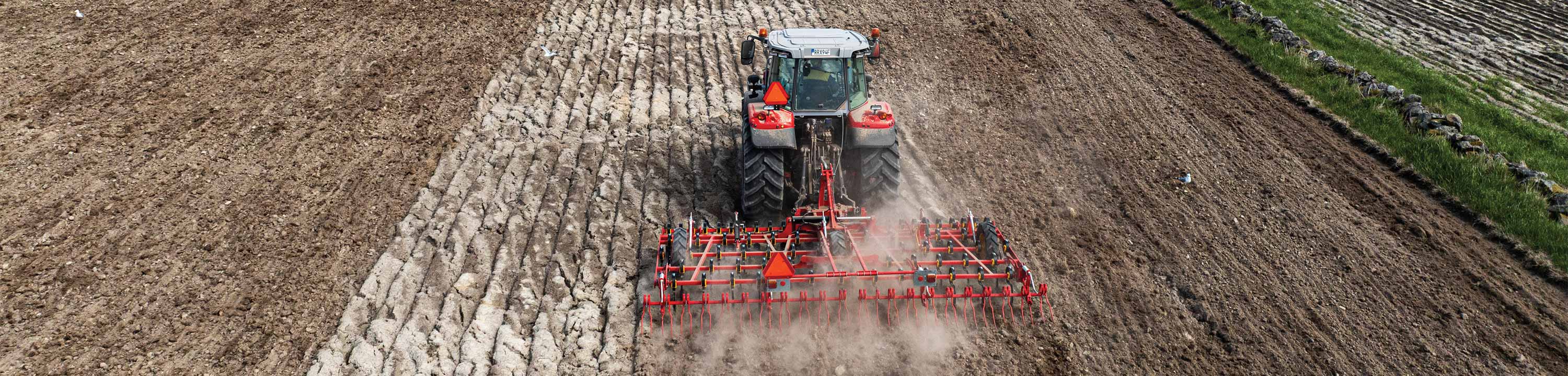 Traktor som harvar på ett fält.