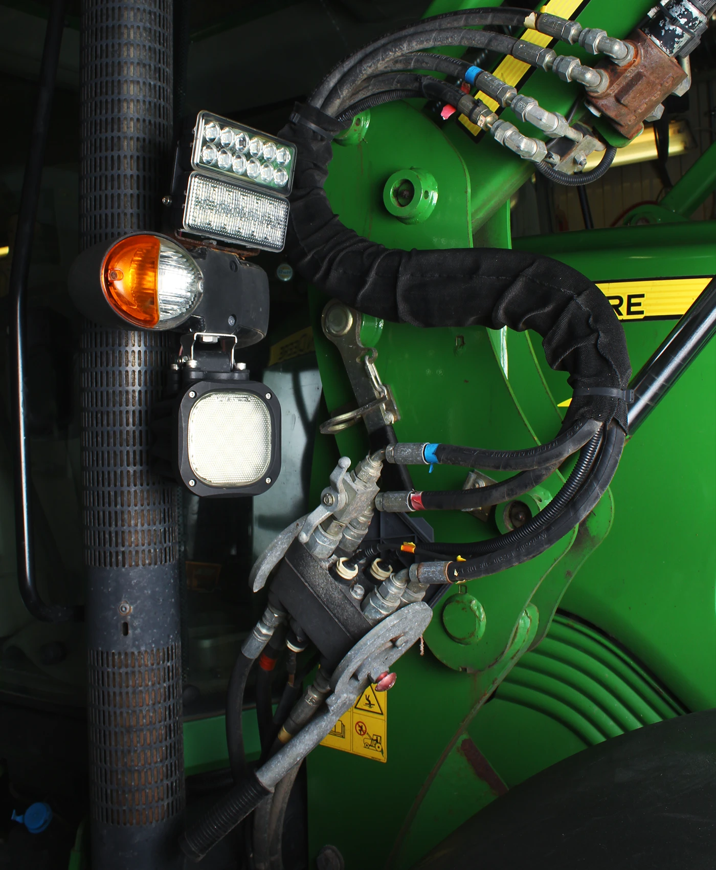 Hydraulik och ventil monterad på en John Deere traktor.