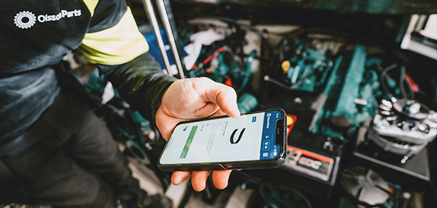 Person holding a phone in front of a Volvo Penta engine.