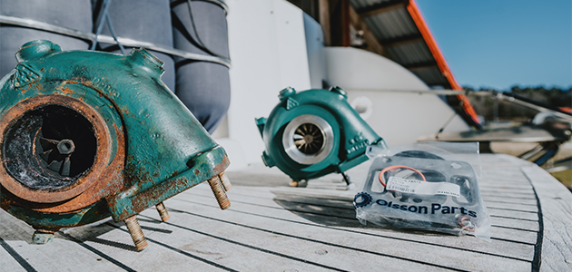 An old and a new turbo compressor placed on a boat deck.