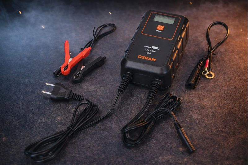 Osram batterilader med kabler og klemmer for tilkobling til et kjøretøybatteri.