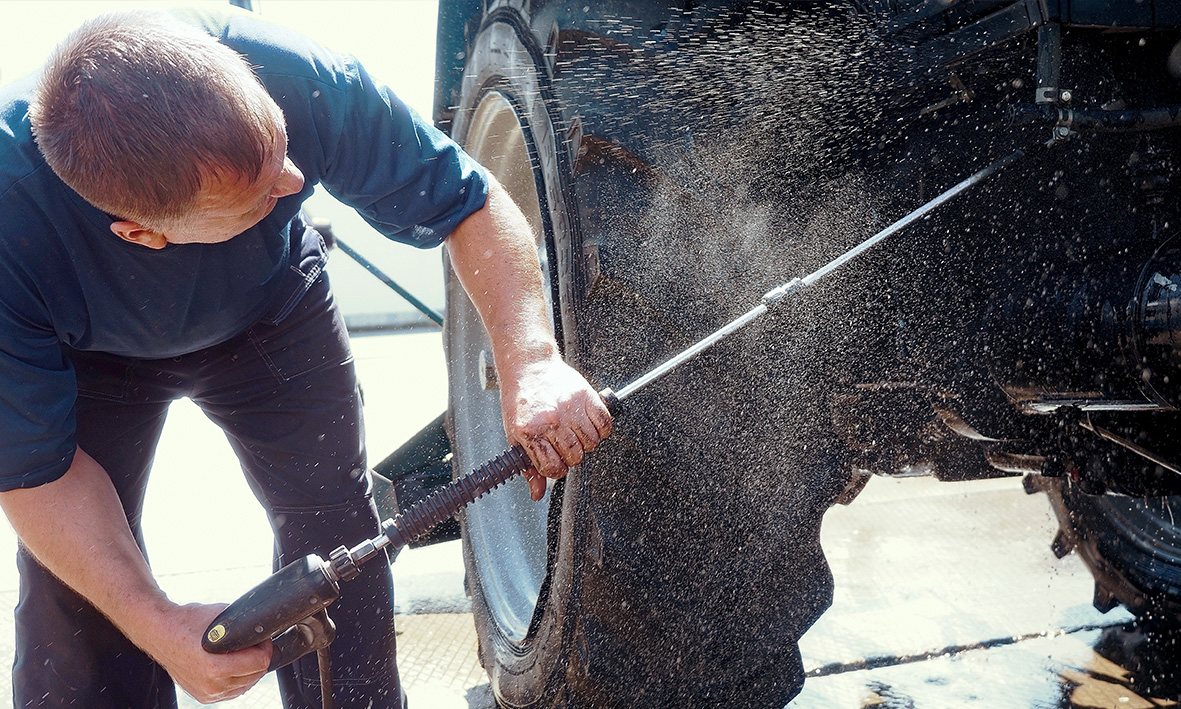 An image of a man washing his tractor