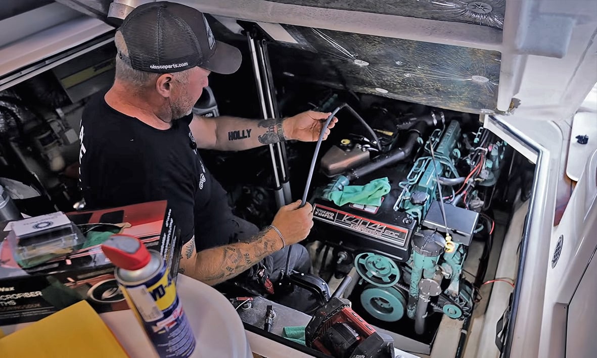 En mann som vinterkonserverer sin Volvo Penta-motor.