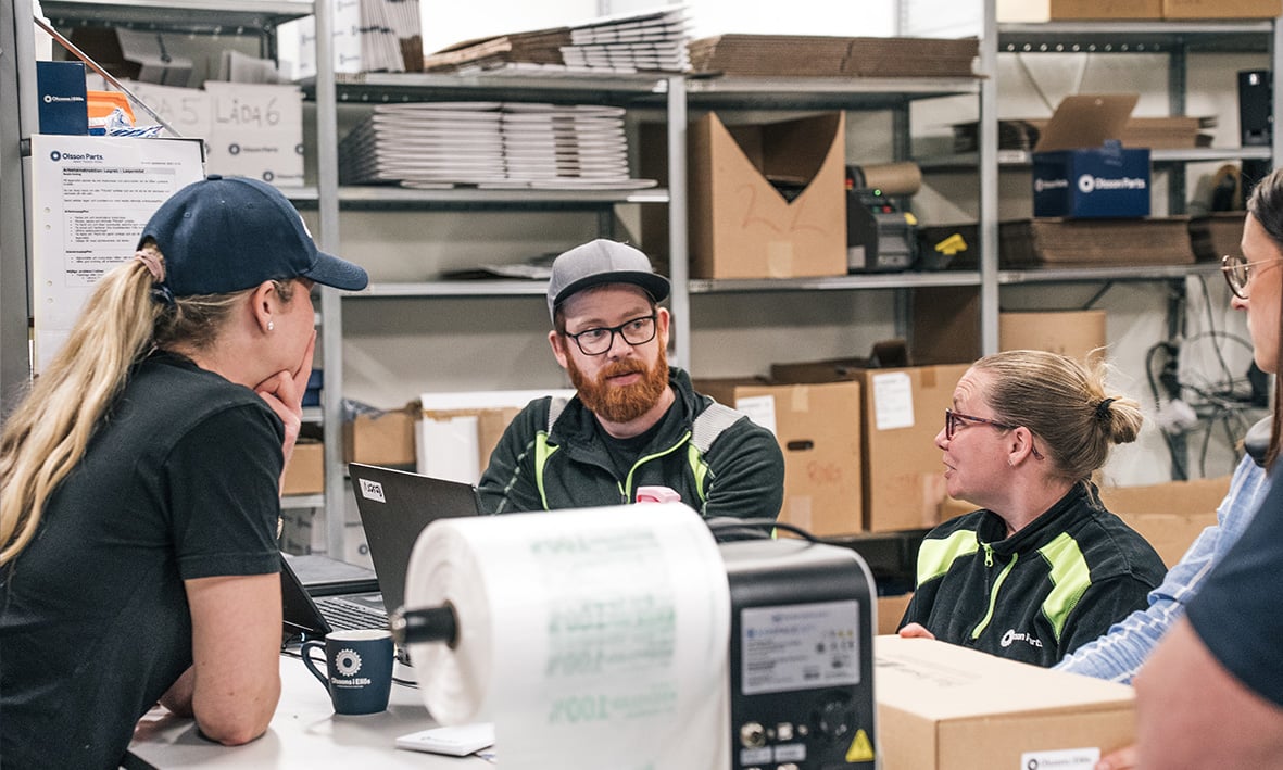 A group of warehouse workers discussing together